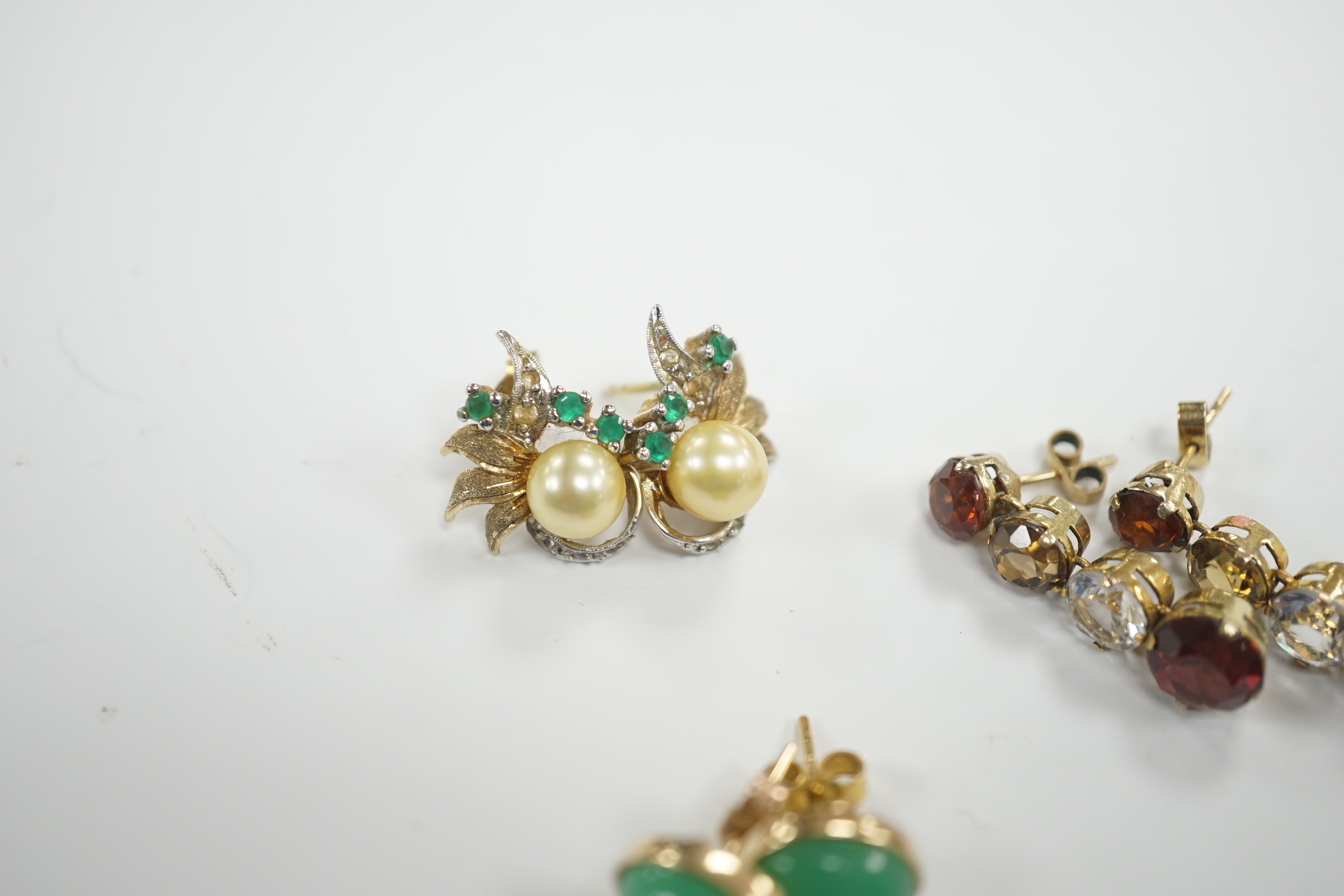 A pair of 1950’s emerald and cultured pearl cluster set earrings, 17mm, a pair of yellow metal and four stone drop earrings and a pair of cabochon chrysoprase ear studs, gross weight 10.3 grams.